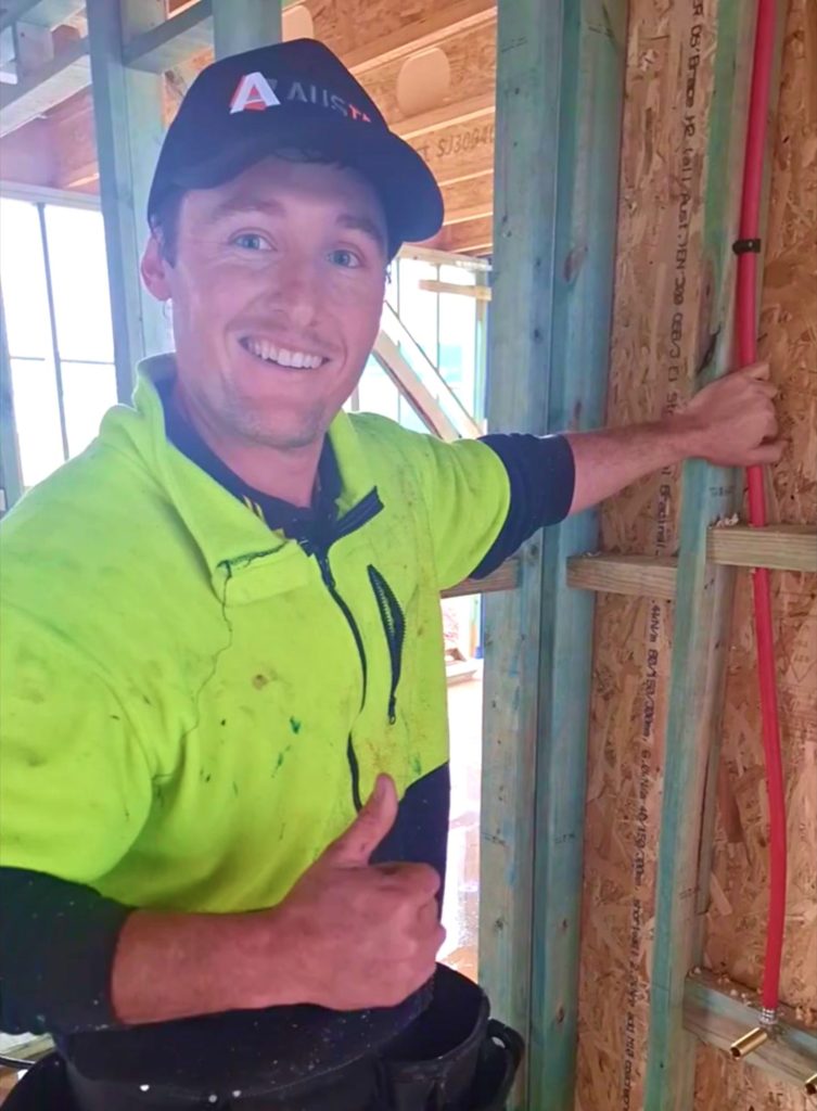 Plumber wearing Austec hat does a thumbs up